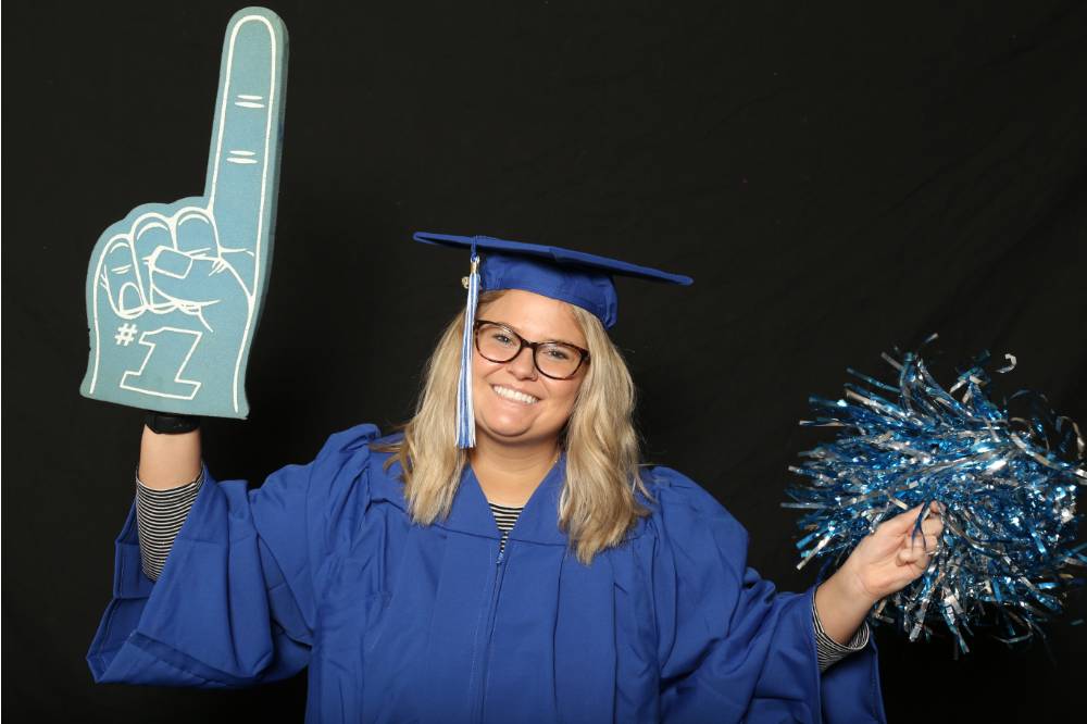 woman poses with foam finger and pompom
